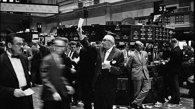 Traders crowd the floor of the New York Stock Exchange in the mid-20th century.